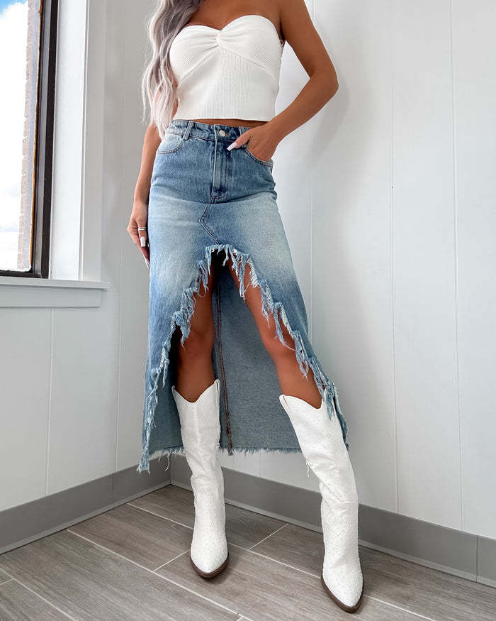 Women's mid-length denim skirt with partially frayed hem and high slit
